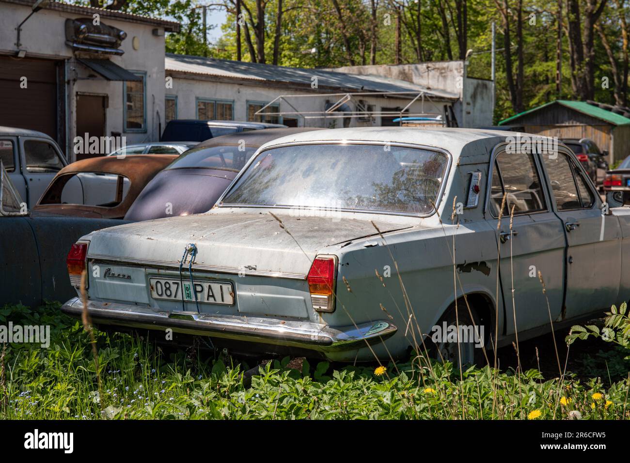 Vecchie auto derelitte nel cantiere di riparazione auto a Kaevuri 1 nel quartiere Kopli di Tallinn, Estonia Foto Stock