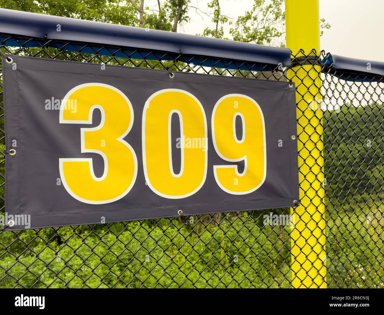 309 piedi ft campo da baseball segno di distanza in giallo e nero montato sulla recinzione di vinile nero. Foto Stock