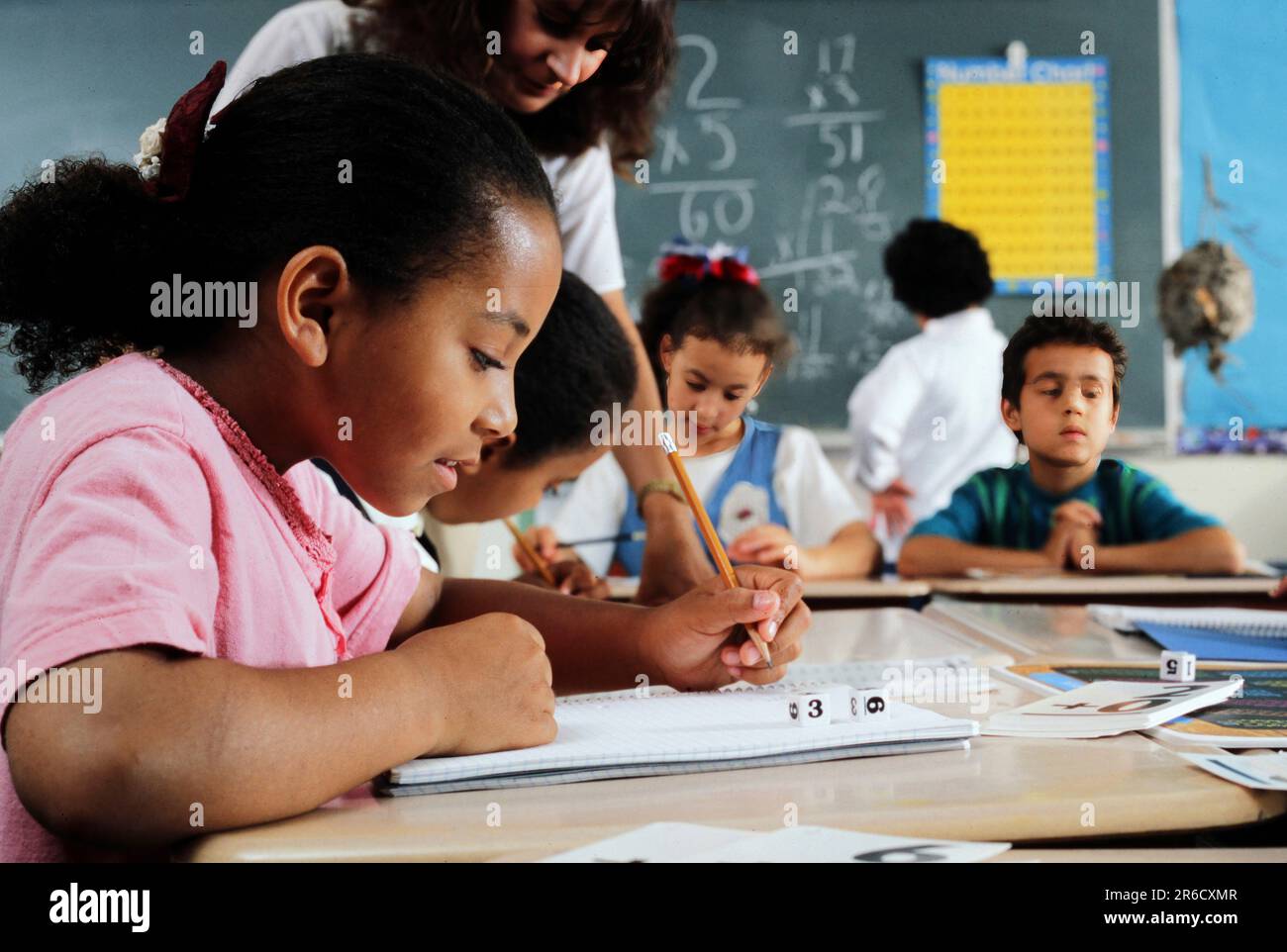 Studente di scuola elementare afro-americana che lavora in un notebook alla sua scrivania Foto Stock