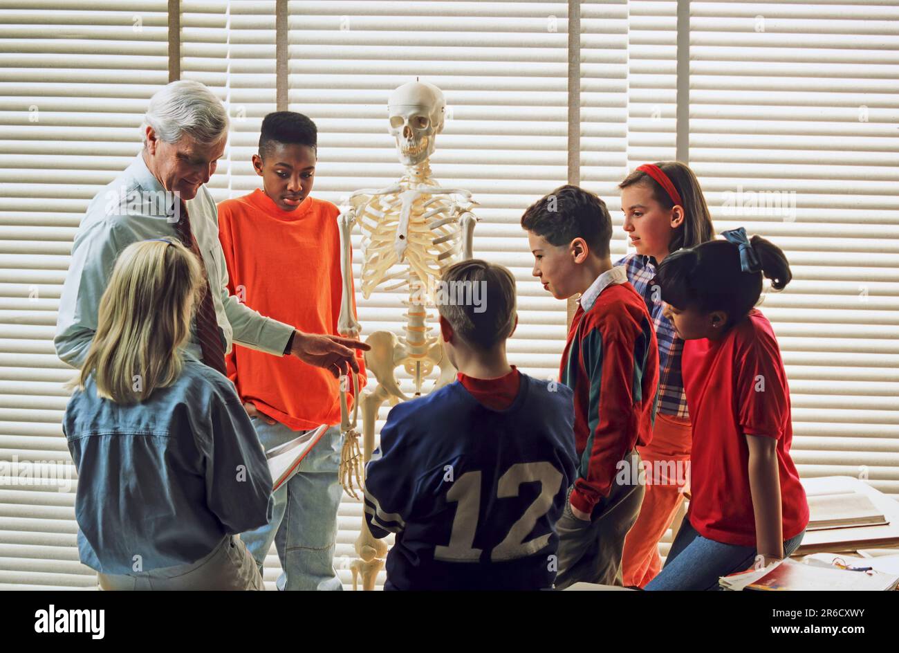 Insegnante di scienze caucasiche che discute di anatomia con un gruppo di studenti di scuole superiori razziali miste Foto Stock