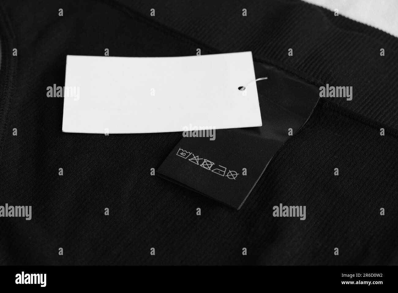 Etichetta di abbigliamento con informazioni sulla cura e etichetta su indumento nero Foto Stock