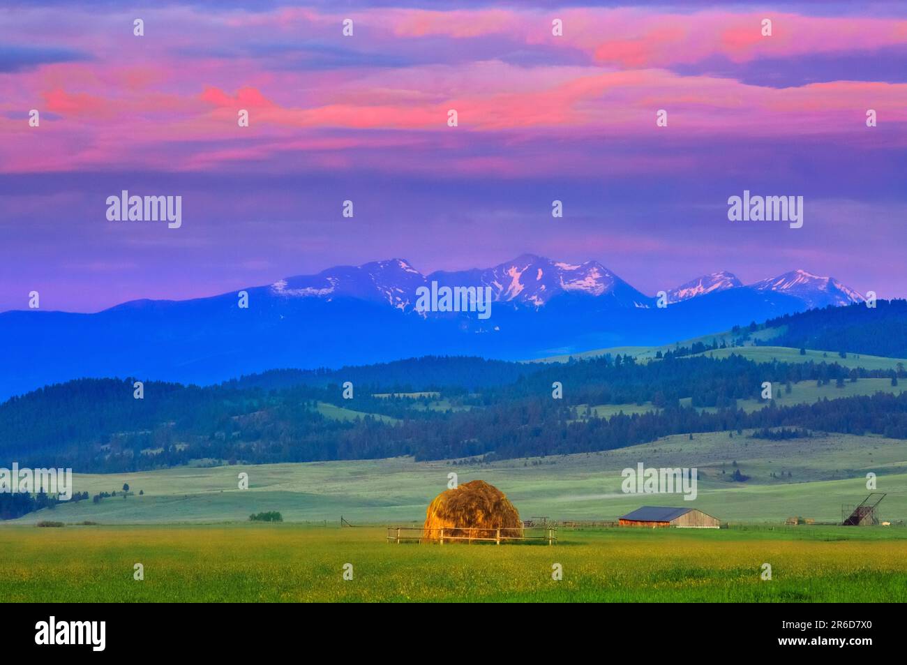 alba su uno stack di fienili in un prato sotto la gamma di torrente selce vicino ad avon, montana Foto Stock