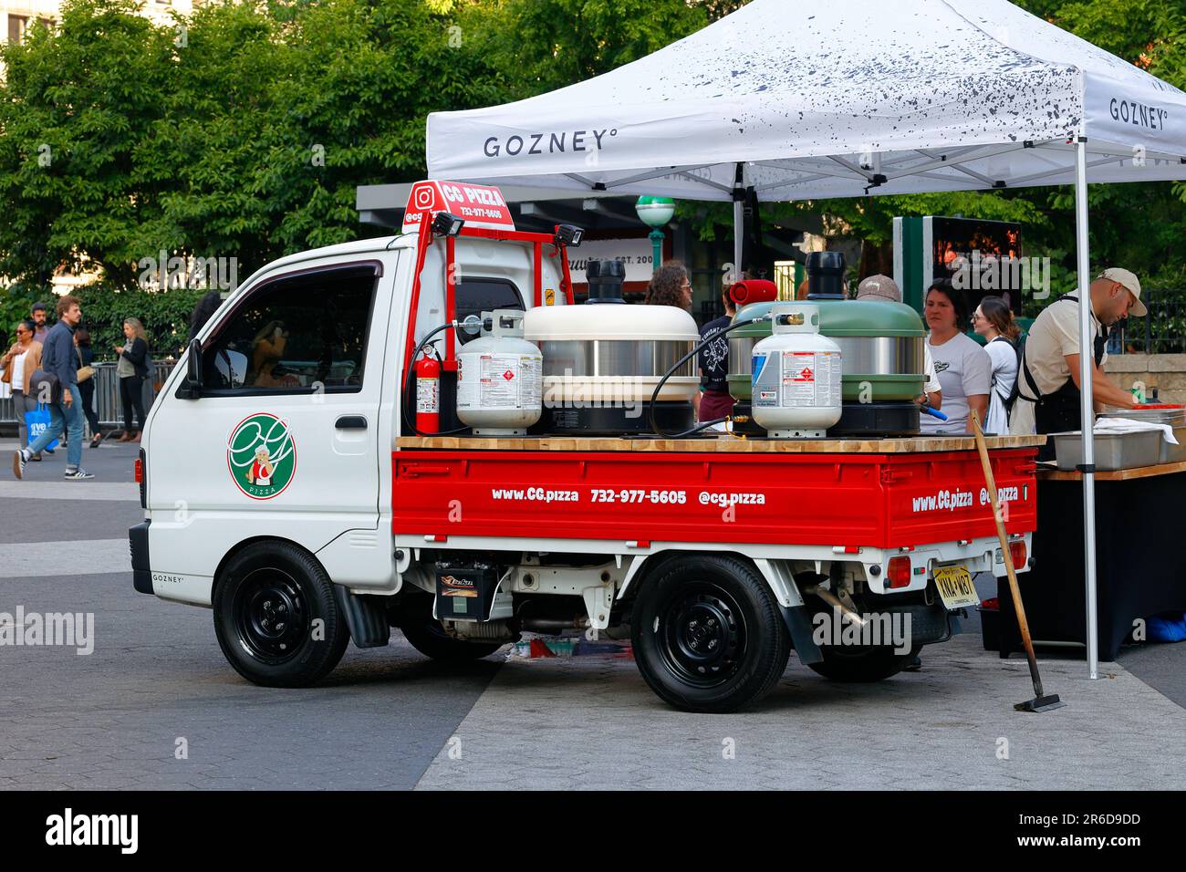Un mini camion giapponese Mitsubishi Minicab 1990s era Kei convertito per trasportare forni portatili per pizza per eventi pop-up CG Pizza. Foto Stock