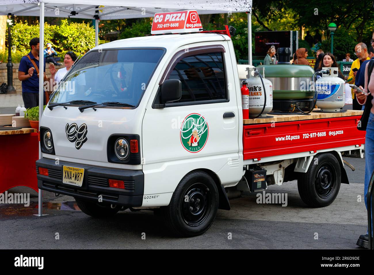 Un mini camion giapponese Mitsubishi Minicab 1990s era Kei convertito per trasportare forni portatili per pizza per eventi pop-up CG Pizza. Foto Stock