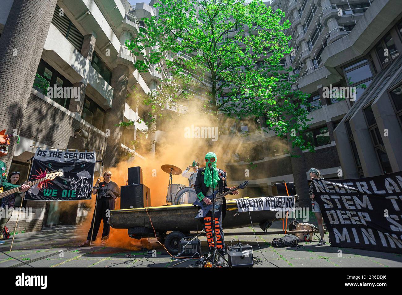 La band heavy-metal di Ocean Rebellion, 'i noduli polimetallici' si esibiscono all'esterno della Camera dei rappresentanti, con fumo colorato come sfondo, durante la dimostrazione del rumore. Il gruppo di attivisti del clima 'Ocean Rebellion' ha organizzato una rumorosa protesta al di fuori degli edifici ministeriali olandesi dell'Aia, del Ministero del clima, della Camera dei rappresentanti, del Ministero delle infrastrutture, del Ministero della gestione delle acque e del Ministero degli affari esteri. Tutti sono stati sottoposti al suono di una band heavy-meatal, 'i noduli polimetallici' suonato al massimo livello per protestare contro l'estrazione in alto mare e il plund Foto Stock