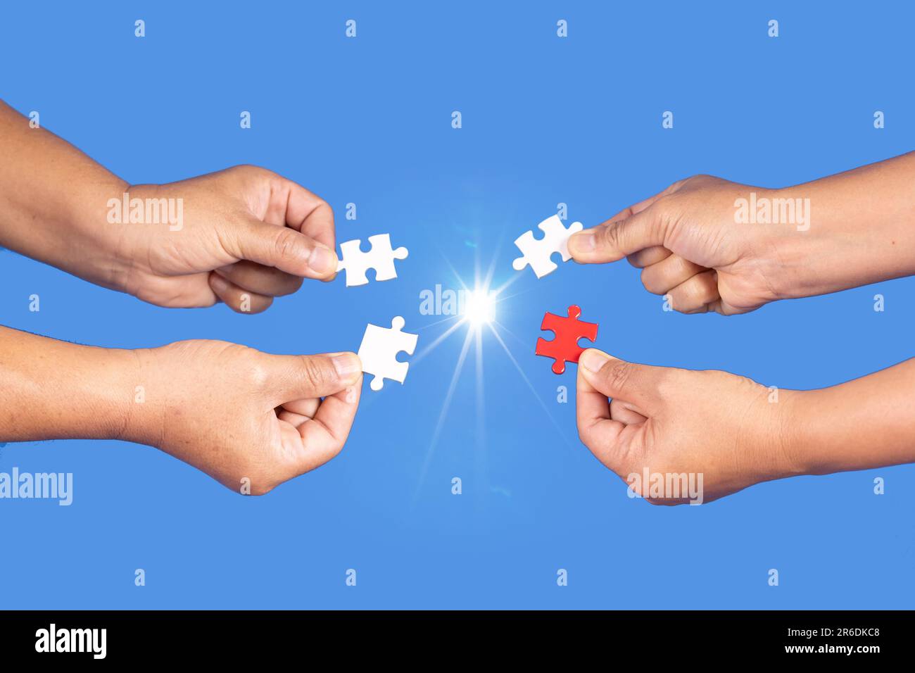 Mani che tengono jigsaw puzzle pezzo con sfondo blu chiaro, business di successo, strategia di soluzione, concetto di partnership lavoro di squadra Foto Stock