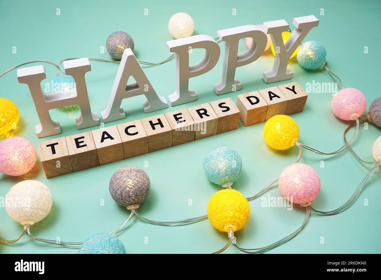 Lettera alfabetica Happy Teachers Day con palle di cotone LED su sfondo verde Foto Stock