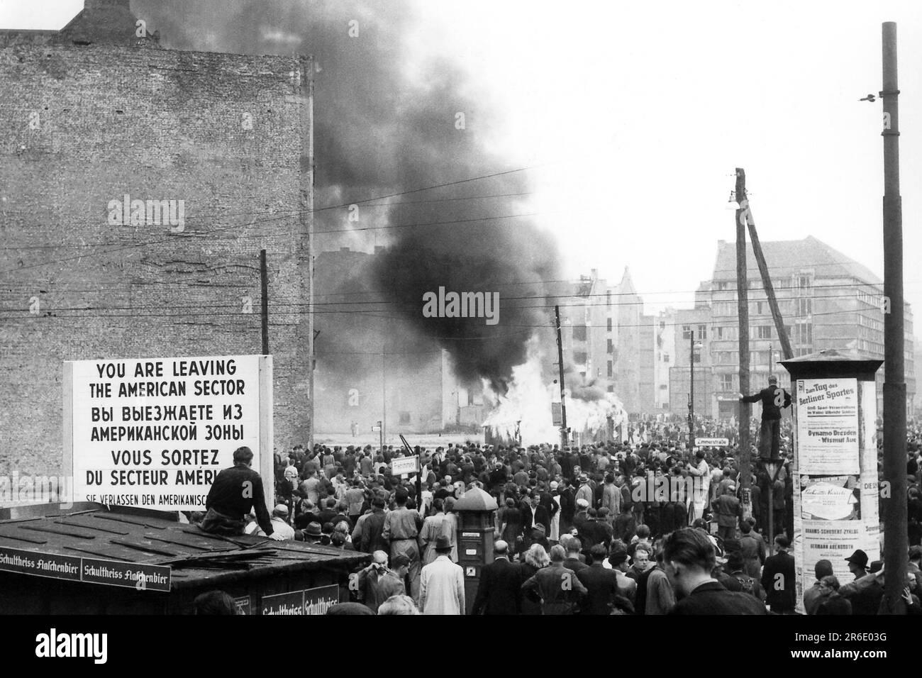 FILED - 17 giugno 1953, Berlino: Vista dal settore americano alla Friedrichstrasse di Berlino Est, dove una casa di controllo della polizia popolare è in fiamme. Il 17 giugno 1953, un milione di persone nella RDT ha protestato contro lo stato socialista ancora giovane - fino a quando i carri armati sovietici non hanno terminato la rivolta. Giorni drammatici. (A dpa 'quando i carri armati rotolano: 70 anni dopo la rivolta popolare nella RDT') Foto: Günter Bratke/dpa Foto Stock