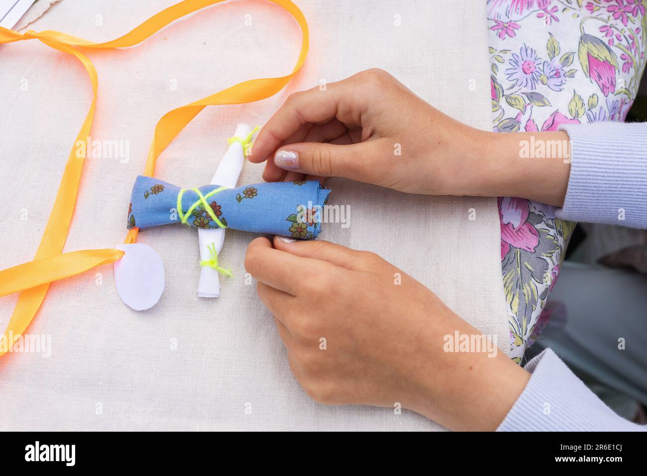 Il bambino ha fatto una bambola amulets da tessuti, che è chiamato Kuvadka, una vecchia tradizione russa Foto Stock