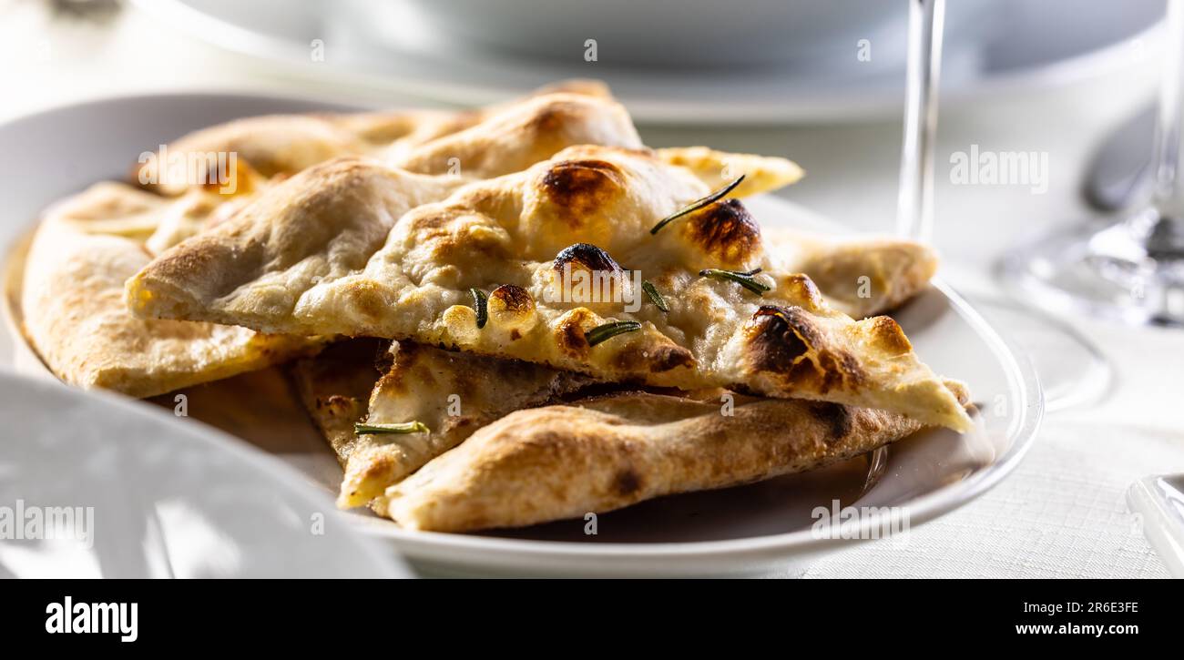Pane di naan caldo fresco affettato e servito su un piatto. Foto Stock