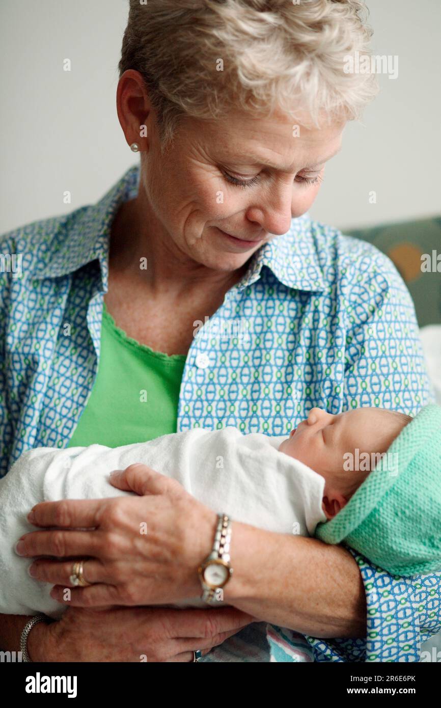 Una donna tiene una bambina appena nata il giorno dopo la sua nascita. Foto Stock