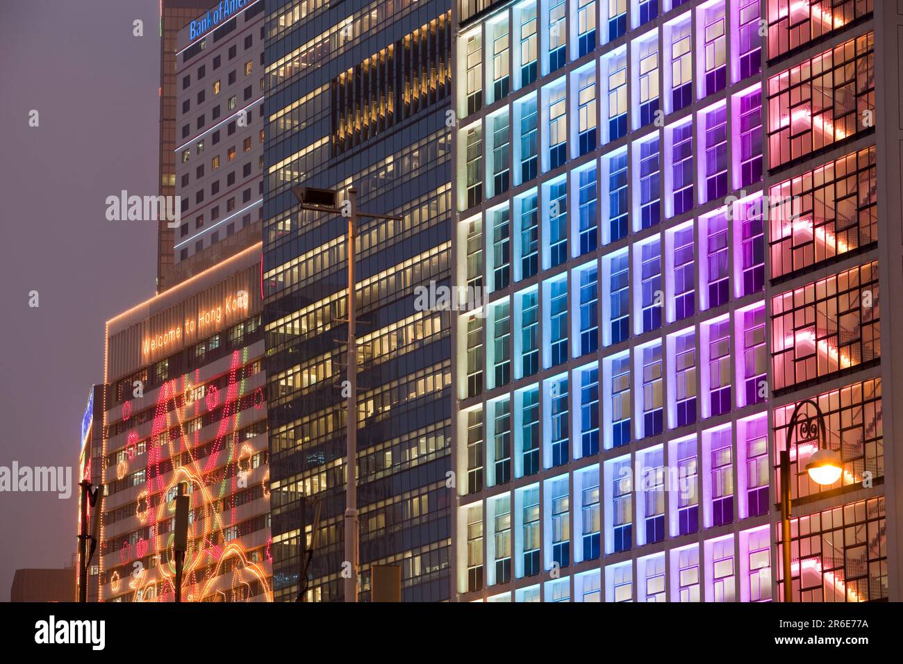 Gli uffici si illuminano di notte a Hong Kong, in Cina. Questa città densamente popolata ha un'enorme impronta di carbonio. Foto Stock