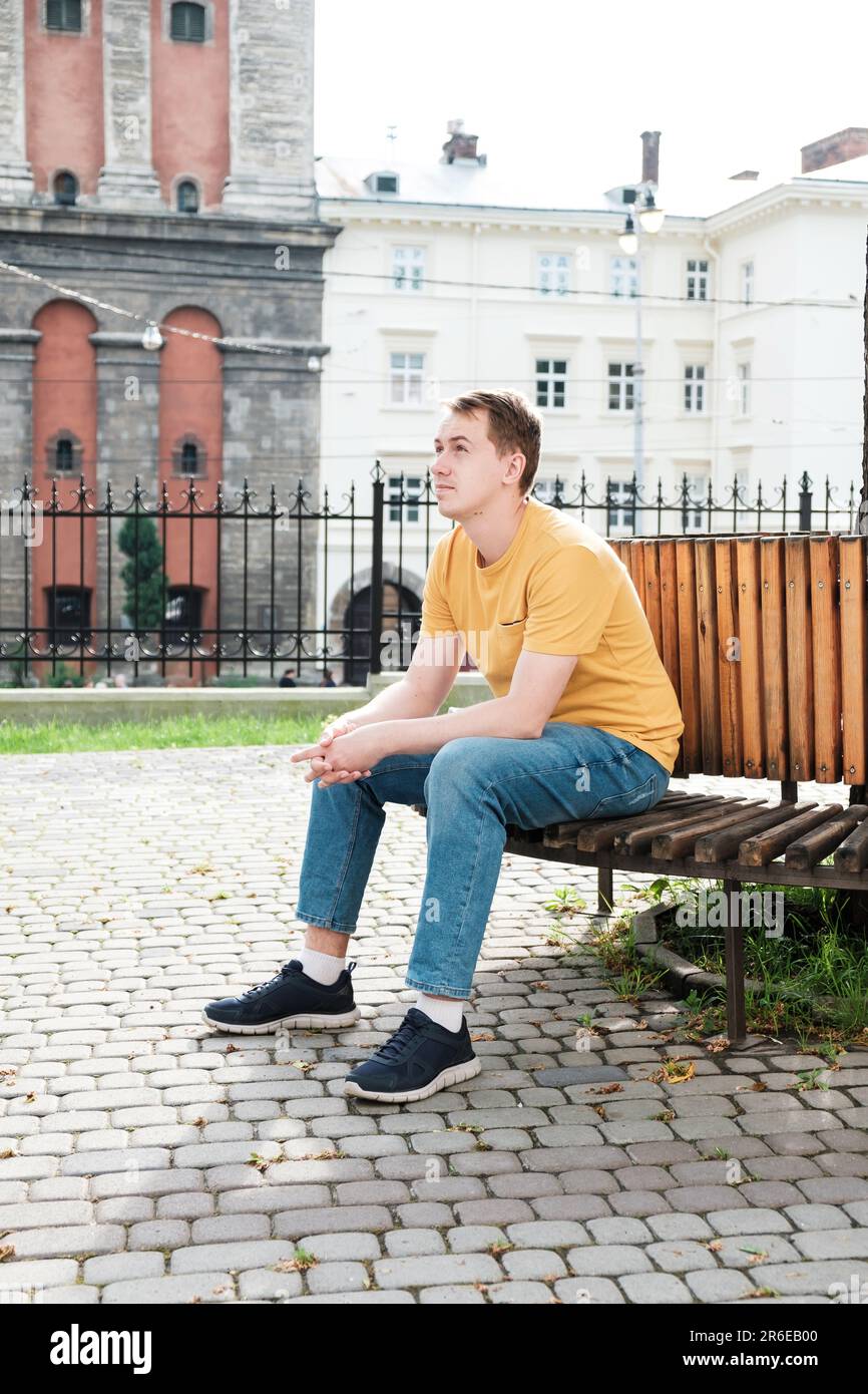 giovane uomo in una t-shirt verde, jeans in un campus Foto Stock