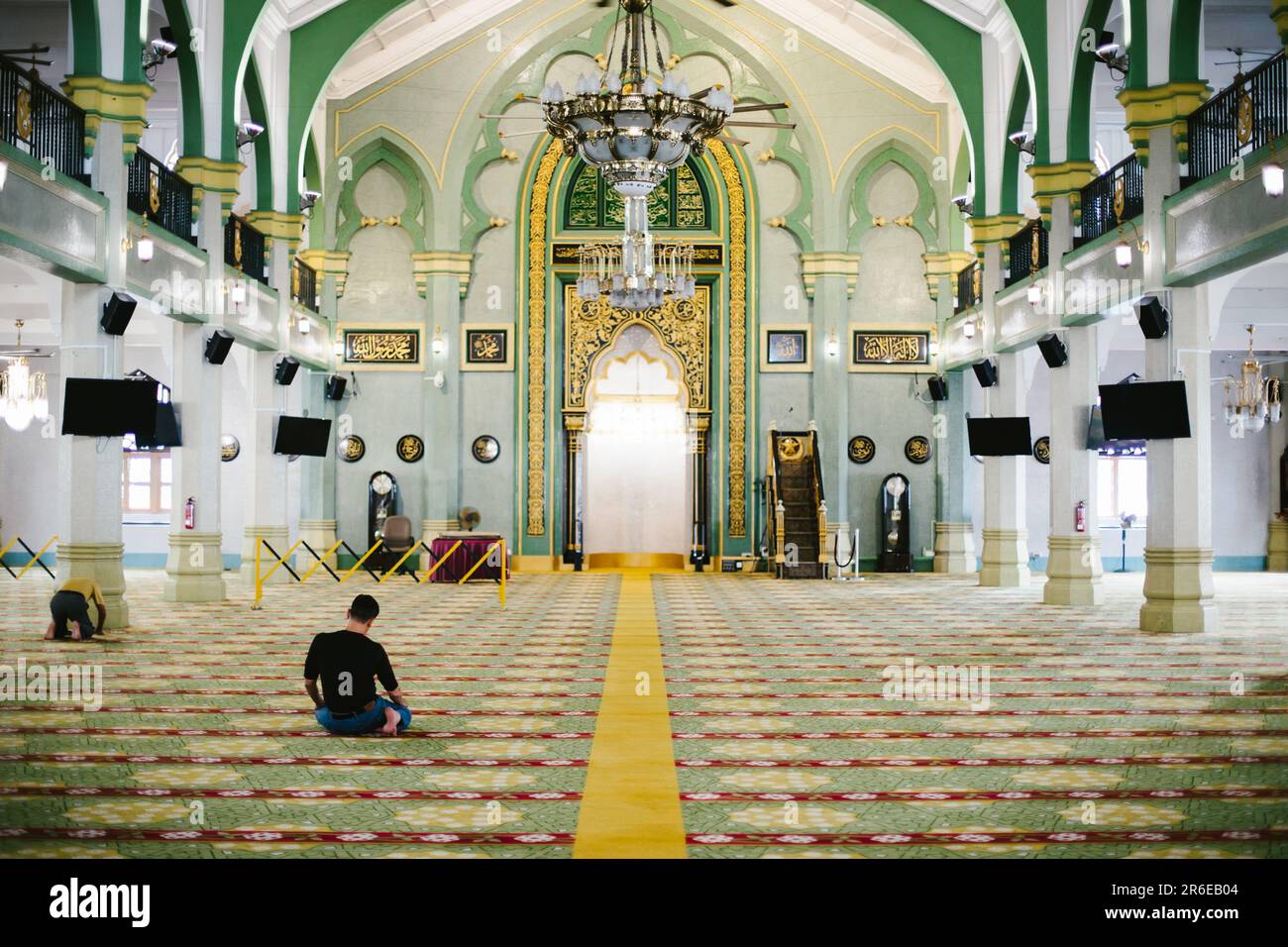 L'uomo prega nella sala della moschea musulmana nel sud-est asiatico Foto Stock