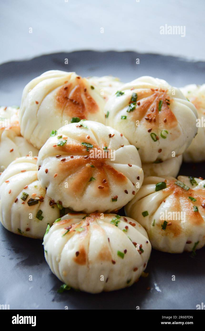 Un piatto bianco con rotoli di khinkali cinesi cotti Foto Stock
