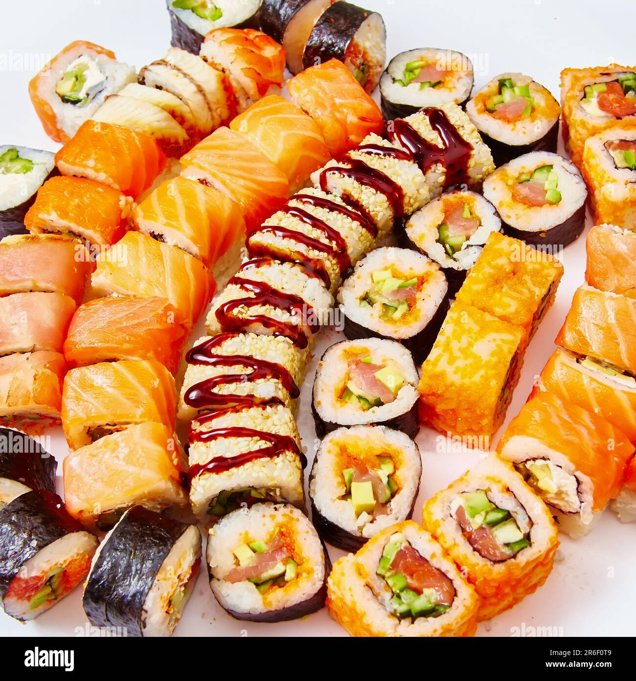 Set di sushi roll con salmone, avocado, formaggio cremoso, cetriolo, riso, tonno su fondo bianco Foto Stock