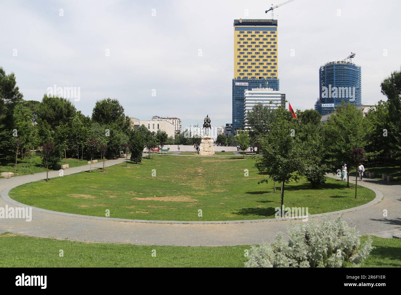 La piazza Skanderbeg (in albanese: Sheshi Skënderbej) è la piazza principale nel centro di Tirana, Albania. La piazza prende il nome dall'eroe nazionale albanese Gjergj Kastrioti Skënderbeu. La superficie totale è di circa 40.000 mq. Il Monumento Skanderbeg domina la piazza. Il piano urbano per Tirana fu inizialmente progettato da Armando Brasini nel 1925 e proseguito da Florestano di Fausto in stile neorinascimentale con soluzioni angolari articolate e fascias di ordine gigante. In seguito all'invasione italiana dell'Albania, il piano regolatore venne aggiornato nel 1939 da Gherardo Bosio. Foto Stock