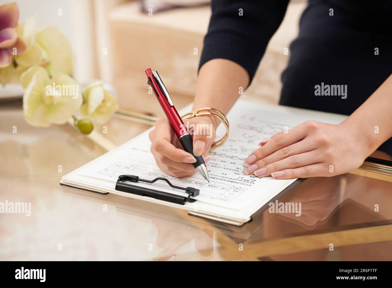 La mano della donna che compila cartelle cliniche e questionari Foto Stock