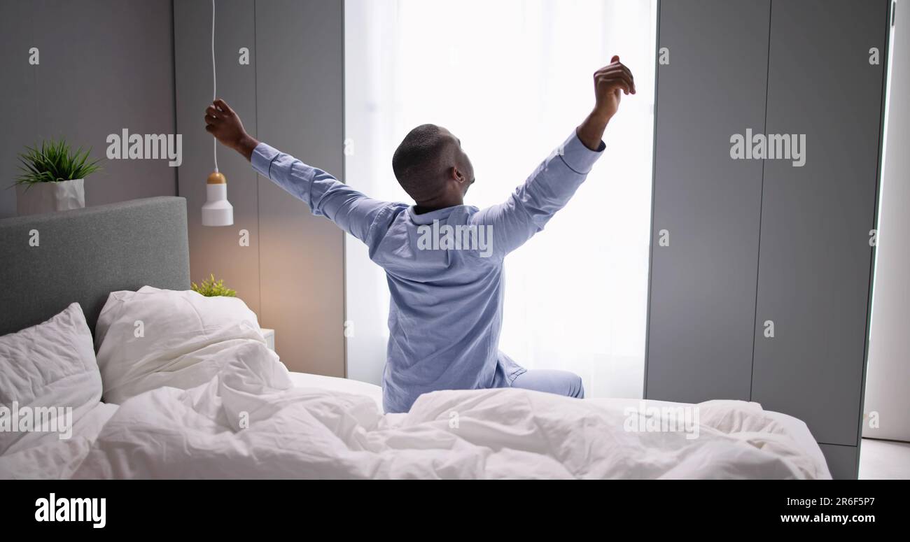 Giovani Sorridenti Africano di svegliarvi in camera da letto Foto Stock