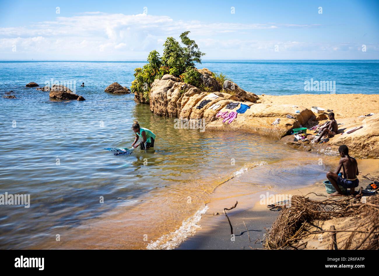 Una donna lava i suoi vestiti nel lago Malawi Foto Stock