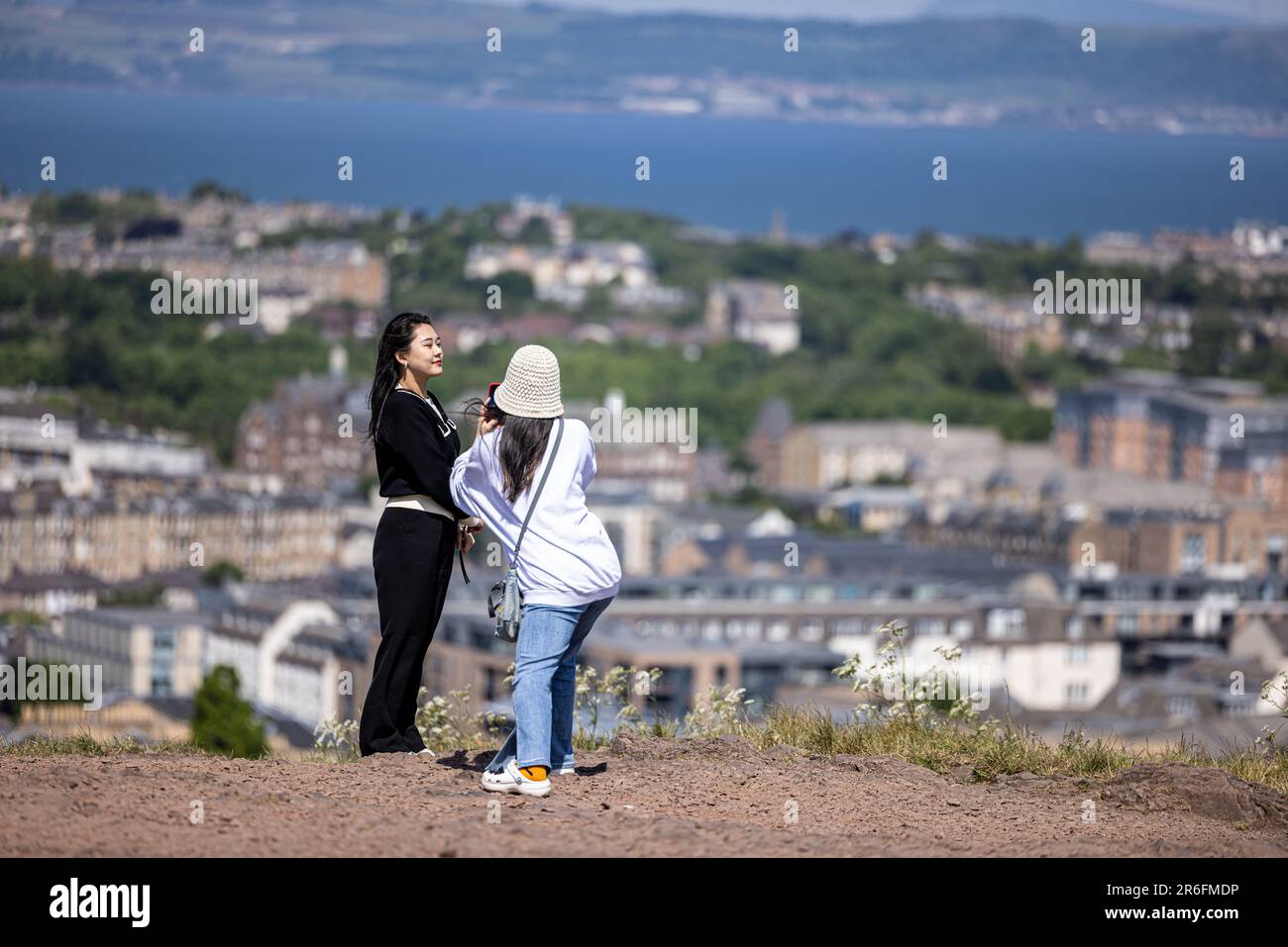 edimburgo, Regno Unito. 09 giugno, 2023 foto: Turisti a Edimburgo scattando fotografie da Calton Hill con la vista verso il porto di Leith. Foto Stock
