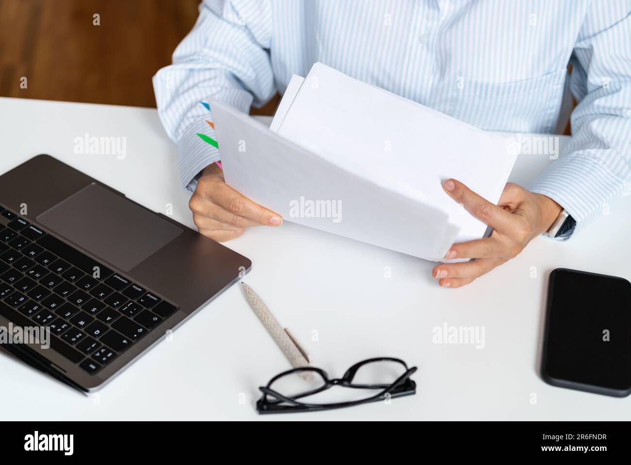 Vista ad alto angolo dei documenti nelle mani del lavoratore del collare bianco, controllo fiscale, contratto di prestito. Foto Stock