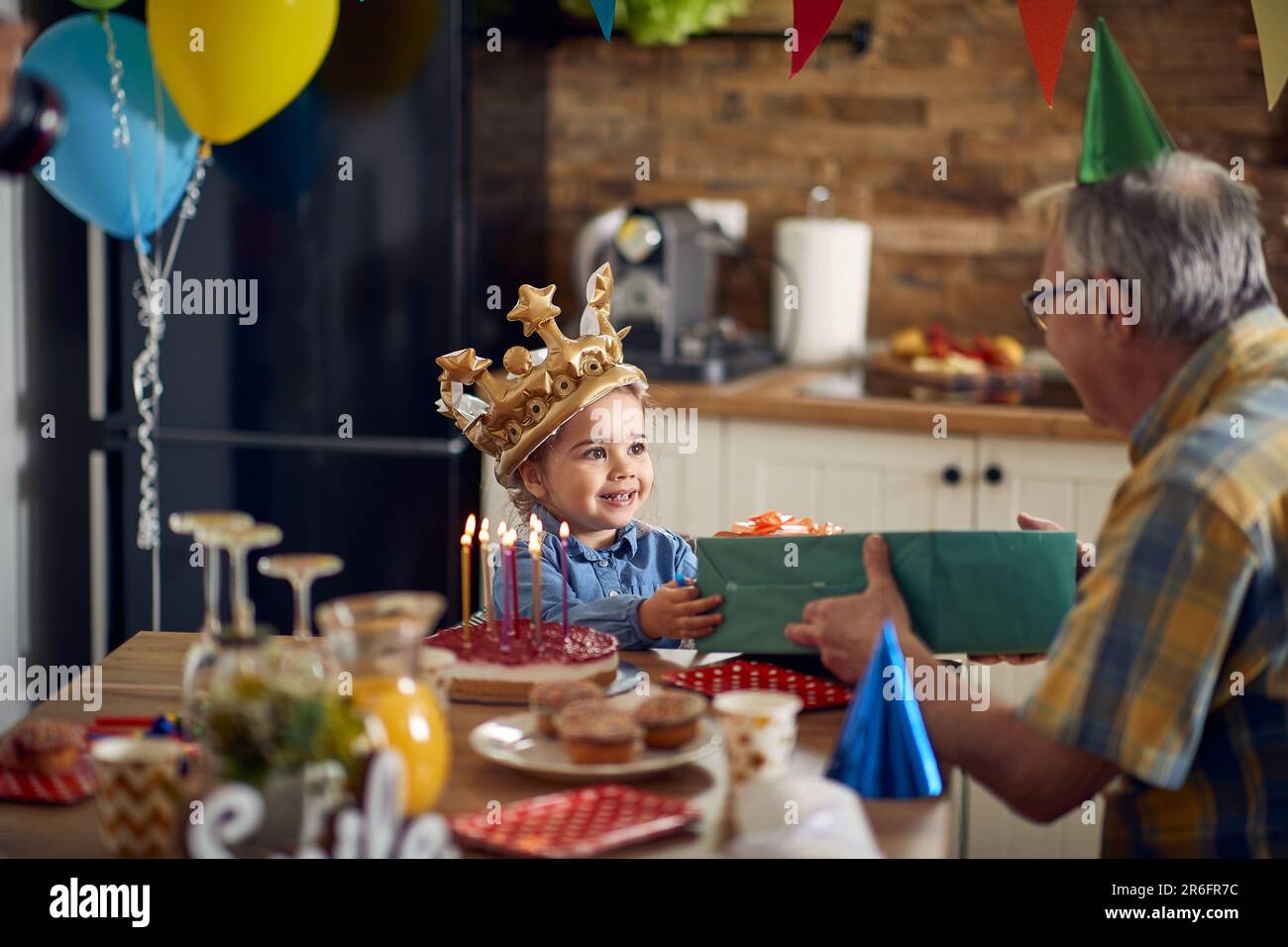 Il dono premuroso del nonno porta un sorriso sul viso, creando ricordi duraturi di amore e gioia. Foto Stock