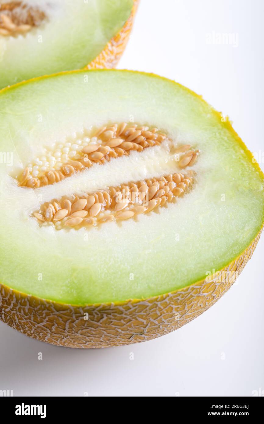 Metà melone e pezzi di melone a fette su sfondo bianco. Foto Stock
