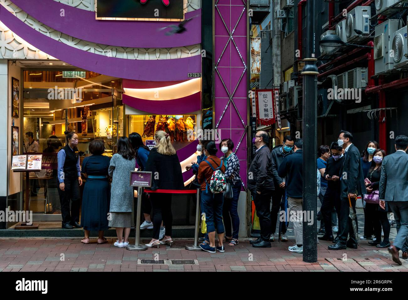 I clienti fanno la coda fuori dal ristorante Tai Hing Roast a pranzo, nel quartiere centrale, Hong Kong, Cina. Foto Stock