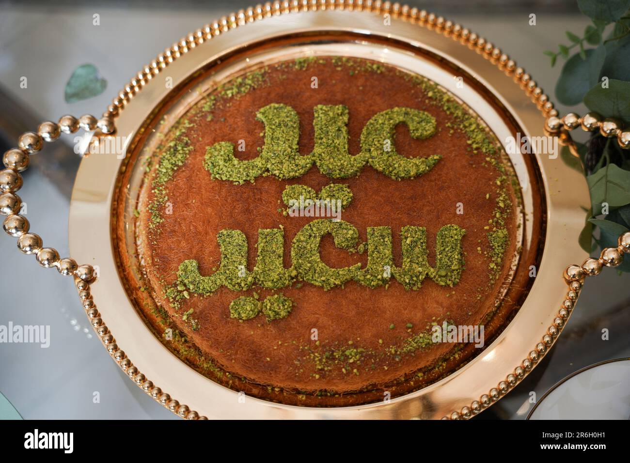 Dessert o torta per le vacanze EID. Kunafa è conosciuta come dolce arabo con la scritta Happy Eid in cima al deserto. Foto Stock