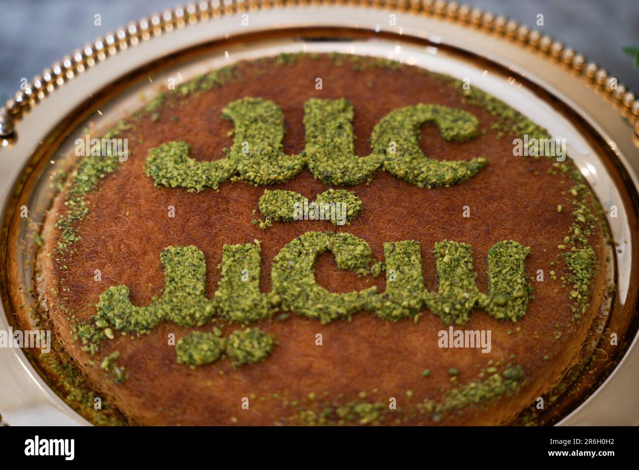 Dessert o torta per le vacanze EID. Kunafa è conosciuta come dolce arabo con la scritta Happy Eid in cima al deserto. Foto Stock