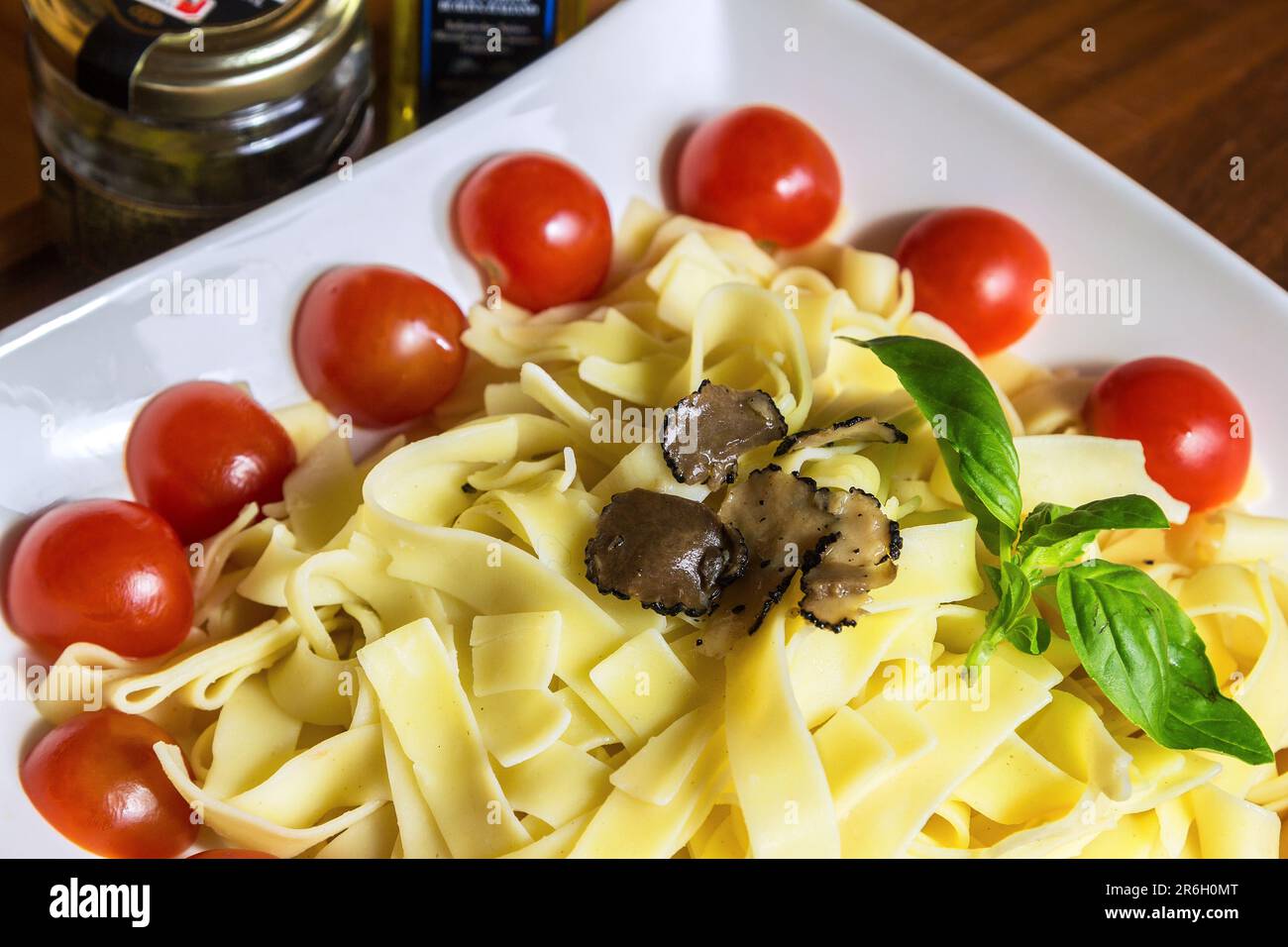 Tagliatelle con fettine di funghi al Tartufo, tomoe di ciliegia e foglia di basilico Foto Stock