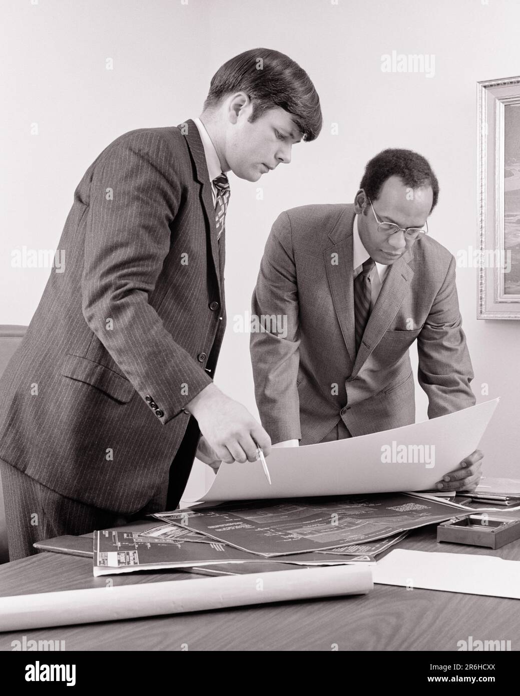 1970S GIOVANE DESIGNER CAUCASICO CHE COLLABORA CON IL VECCHIO UOMO AFROAMERICANO CONSULENZA SU BLUEPRINTS SIA IN TUTA CHE CRAVATTA - O3058 HAR001 HARS ARCHITETTURA GENERALE COPIA SPAZIO PERSONE DI MEZZA LUNGHEZZA MASCHI ARCHITETTO BLUEPRINTS B&W PARTNER OBIETTIVI SUCCESSO TUTA E CRAVATTA STRUTTURA ENTRAMBI I CONSULENTI ARCHITETTI CUSTOMER SERVICE DESIGNER AFRO-AMERICANI AFRO-AMERICANI E LEADERSHIP NERO ETNICITÀ LAVORO IN ON OPPORTUNITÀ DI LAVORO OCCUPAZIONE DI CONNESSIONE SOCIETÀ SOCIETÀ DI PARTNERSHIP COOPERAZIONE TRA I DIPENDENTI UOMO MEDIO-ADULTO PARTNER SOLUZIONI GIOVANE NERO E BIANCO CAUCASICO ETNIA APPALTATORE Foto Stock