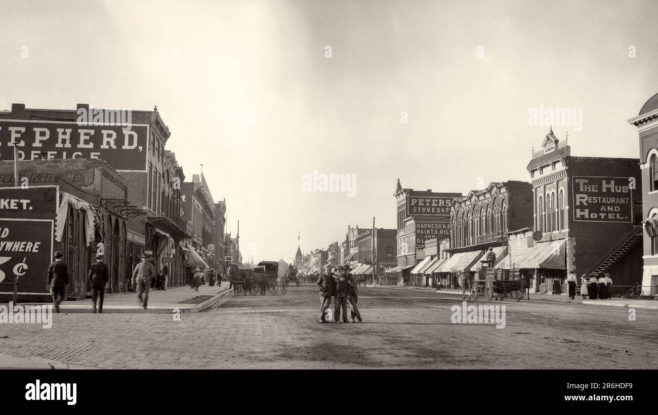 1900S 1910 TRE RAGAZZI IN PIEDI NEL CENTRO DI COMMERCIAL STREET GUARDANDO LA MACCHINA FOTOGRAFICA ALTRI UOMINI CHE CAMMINANO SUL MARCIAPIEDE EMPORIA KANSAS USA - Q45703 CPC001 HARS ARCHITETTURA TRASPORTO STATI UNITI COPIA SPAZIO AMICIZIA PERSONE A LUNGHEZZA INTERA STATI UNITI D'AMERICA MASCHI KANSAS EDIFICI RUOTE TRASPORTO B&W NORD AMERICA NORD AMERICA GRANDANGOLO STRUTTURA CENTRO URBANO MAMMIFERI PROPRIETÀ KS PROGRESSO TRIO IMMOBILIARE STRUTTURE VAGONI EDIFICIO EMPORIA CRESCITA MAMMIFERO TOGETHERNESS BIANCO E NERO GRANDI PIANURE MAIN STREET MIDWEST VECCHIO STILE Foto Stock