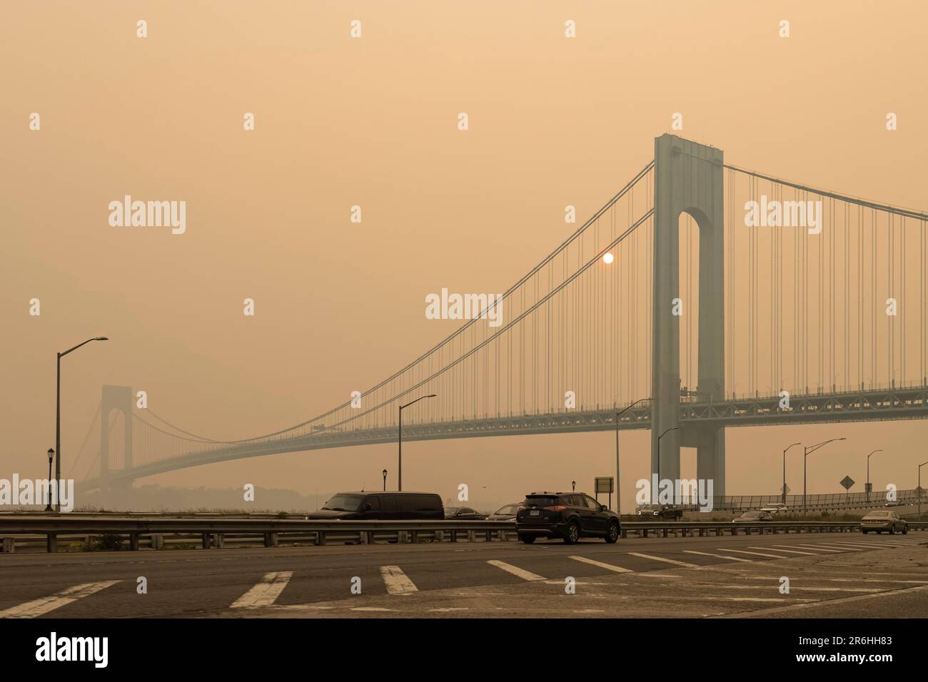 Vista sul ponte Verrazzano-Narrows e sulla città di New York sorpresi dal fumo di arancio intenso dei fuochi selvatici del Québec Foto Stock