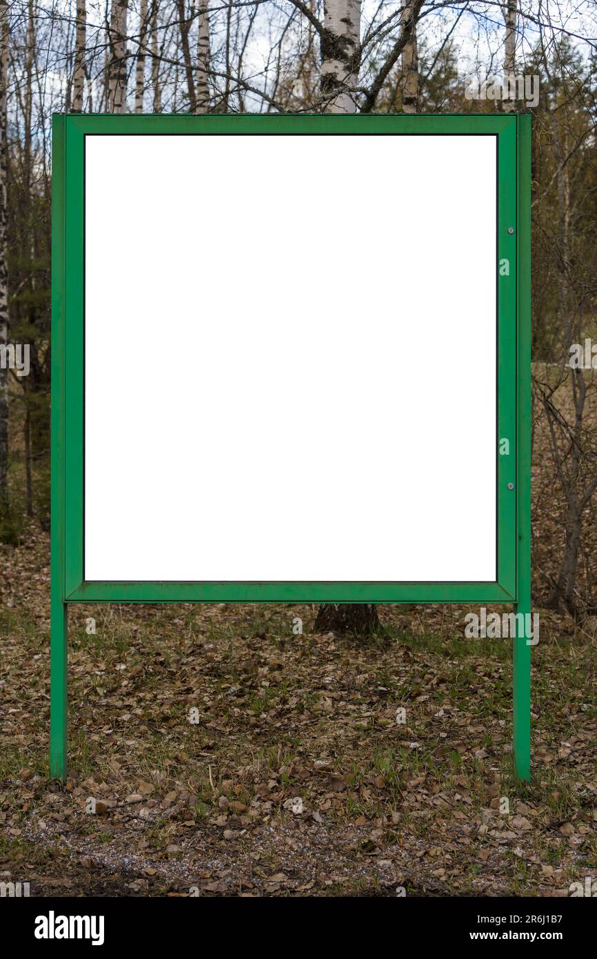 Affissioni bianche vuote con cornice verde e natura sullo sfondo. Foto Stock