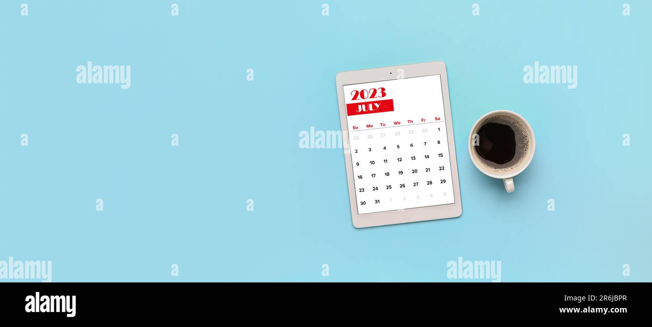 Calendario del 2023 luglio su schermo di computer tablet e tazza di caffè su sfondo azzurro con spazio per il testo Foto Stock