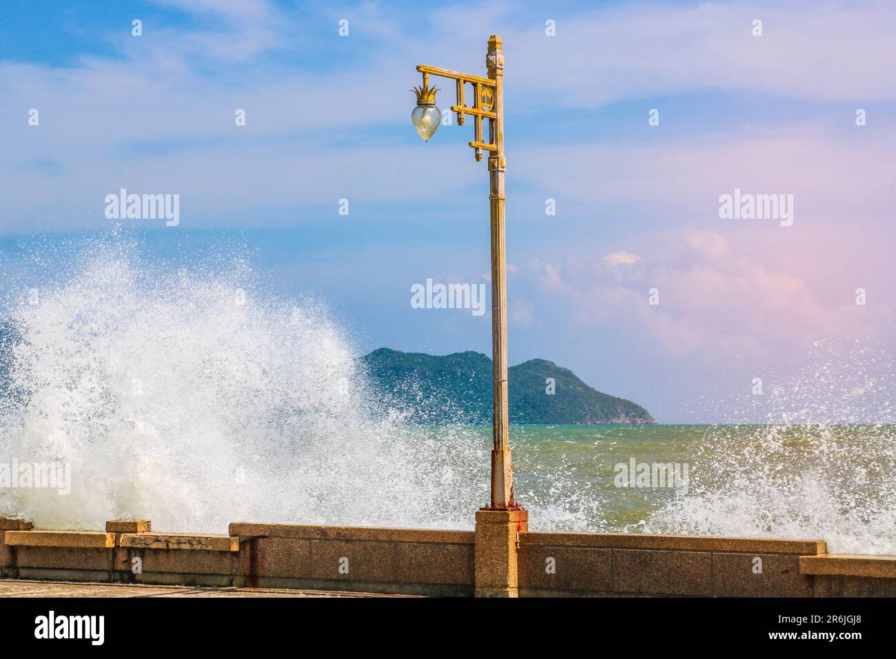 Surf forte, onde alte con spruzzi, un mare infuriato, una lanterna sul terrapieno. Foto Stock