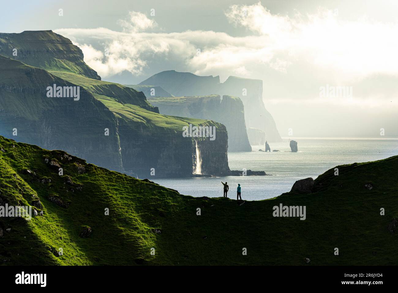 Silhouette di escursionisti che ammirano le scogliere in cima alla cresta di montagna sopra l'oceano, l'isola di Kalsoy, le isole Faroe, la Danimarca, l'Europa Foto Stock