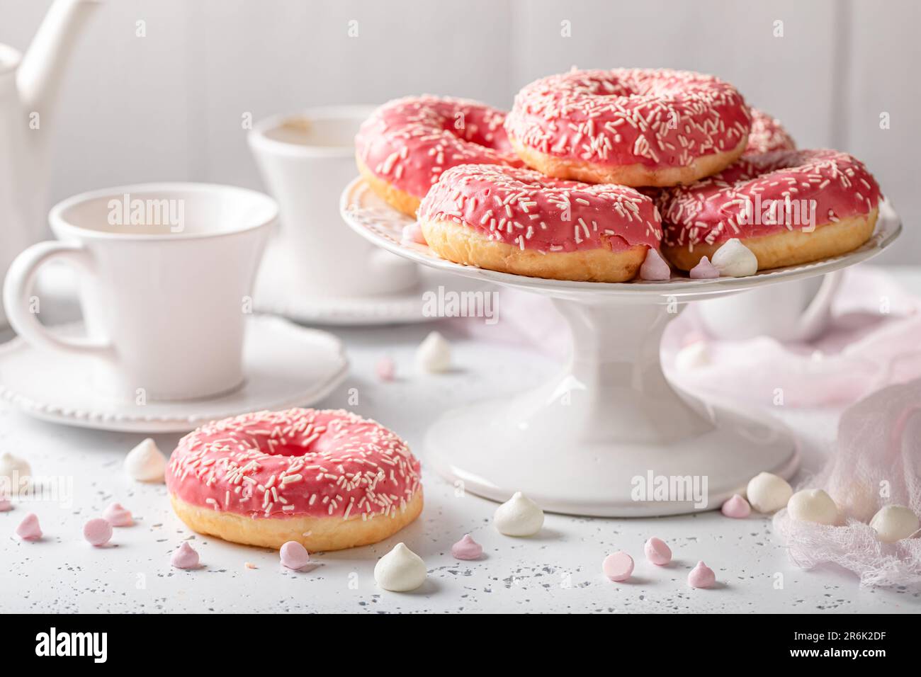 Ciambelle rosa dolci e fatte in casa e caffè come snack perfetto. Le ciambelle e il caffè sono il miglior dessert di sempre. Foto Stock