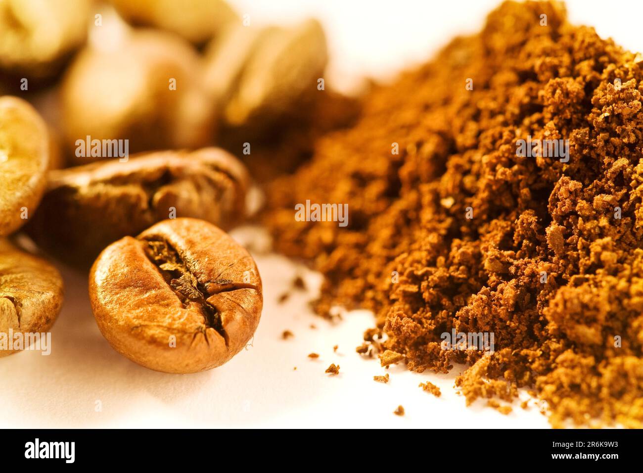 Chicchi di caffè e polvere di caffè su sfondo bianco Foto Stock