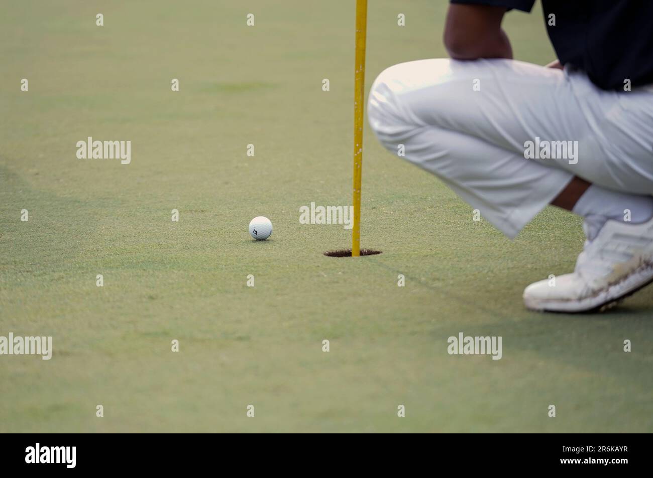 Giacarta, Indonesia - 5 giugno 2023: I golfers mettono a fuoco sulla sfera per assicurarsi che compiono le misure adeguate mettere la sfera di golf nel foro. Foto Stock