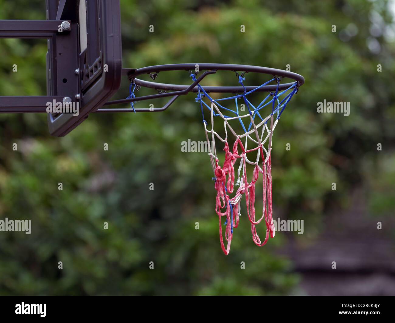 primo piano della rete da basket con sfondo a foglie sfocate Foto Stock