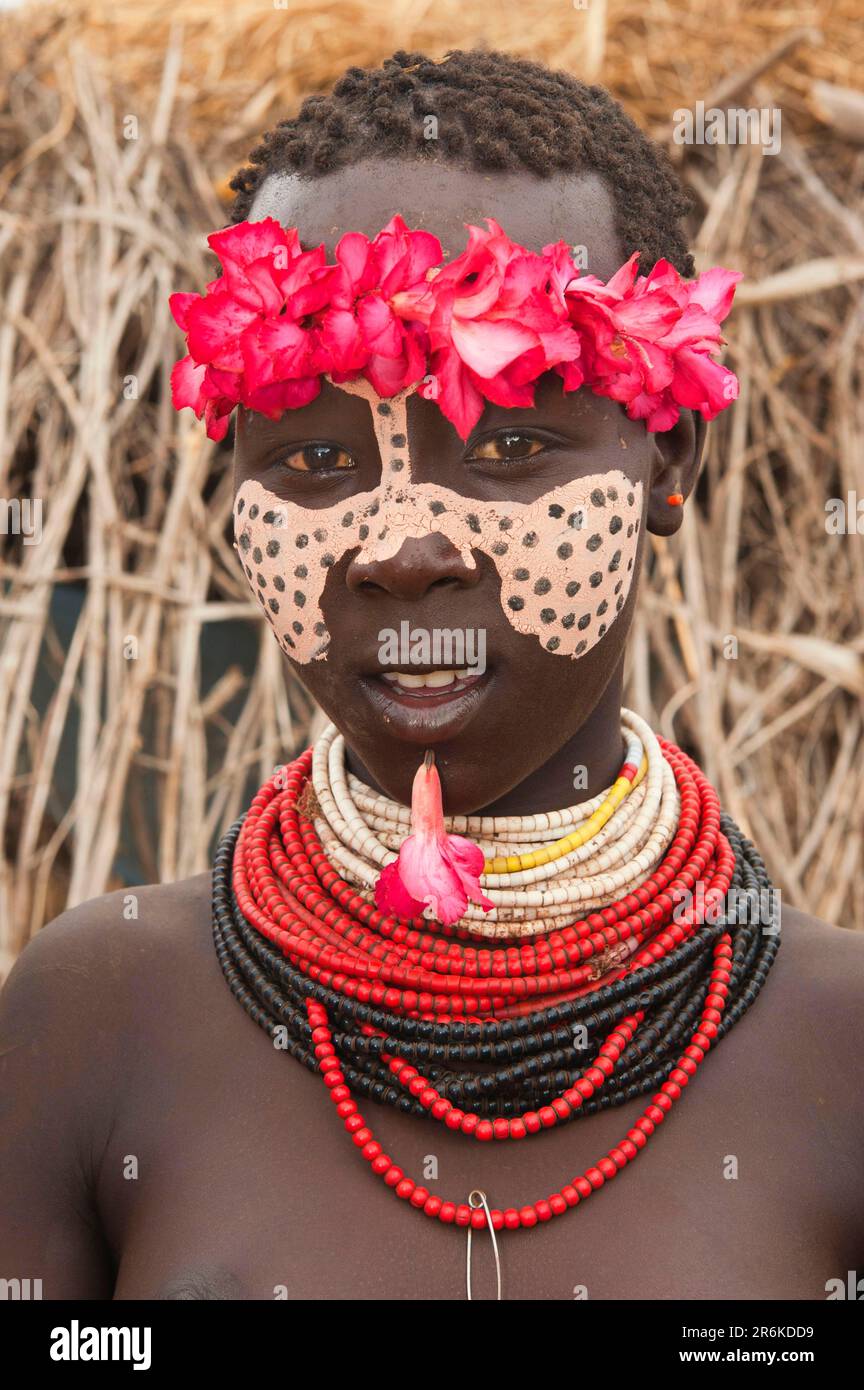 Karo ragazza con corona di fiori, pittura facciale, collane colorate e piercing labbra, Omo Valley, Etiopia meridionale, Karo Foto Stock