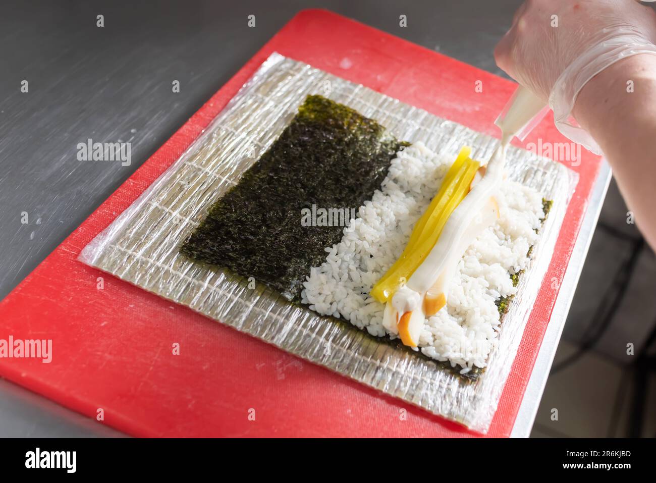 Cucinare sushi con daikon, formaggio e calamari affumicati. Foto di alta qualità Foto Stock