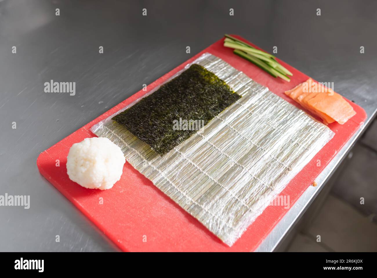Ingredienti per preparare il sushi roll con salmone, formaggio e cetriolo. Foto di alta qualità Foto Stock