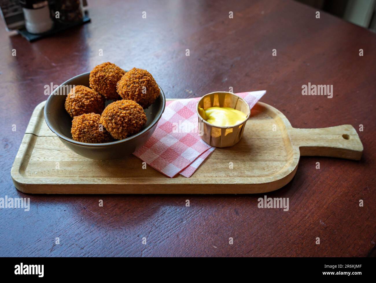 Bitterballen, uno spuntino tipico olandese simile alle crocchette, servito con salsa di senape, focus selettivo Foto Stock