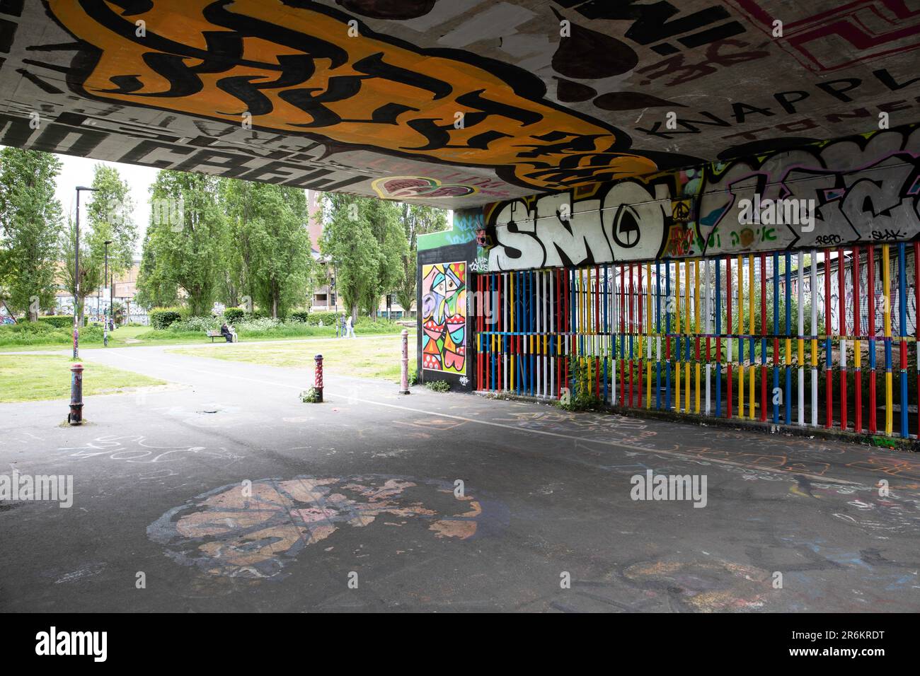 Londra, Regno Unito - Maggio 17 2023: Guardando fuori da sotto un ponte ferroviario verso gli Allen Gardens a Shoreditch. La scena colorata è composta da graffiti. Foto Stock