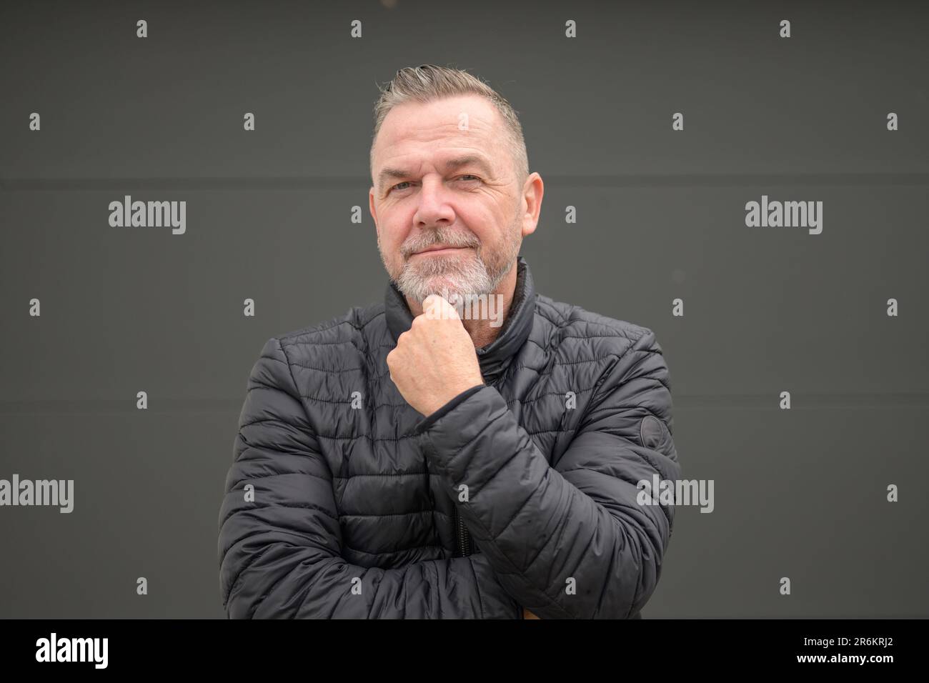 Uomo di mezza età che tiene il mento e guarda alla fotocamera Foto Stock