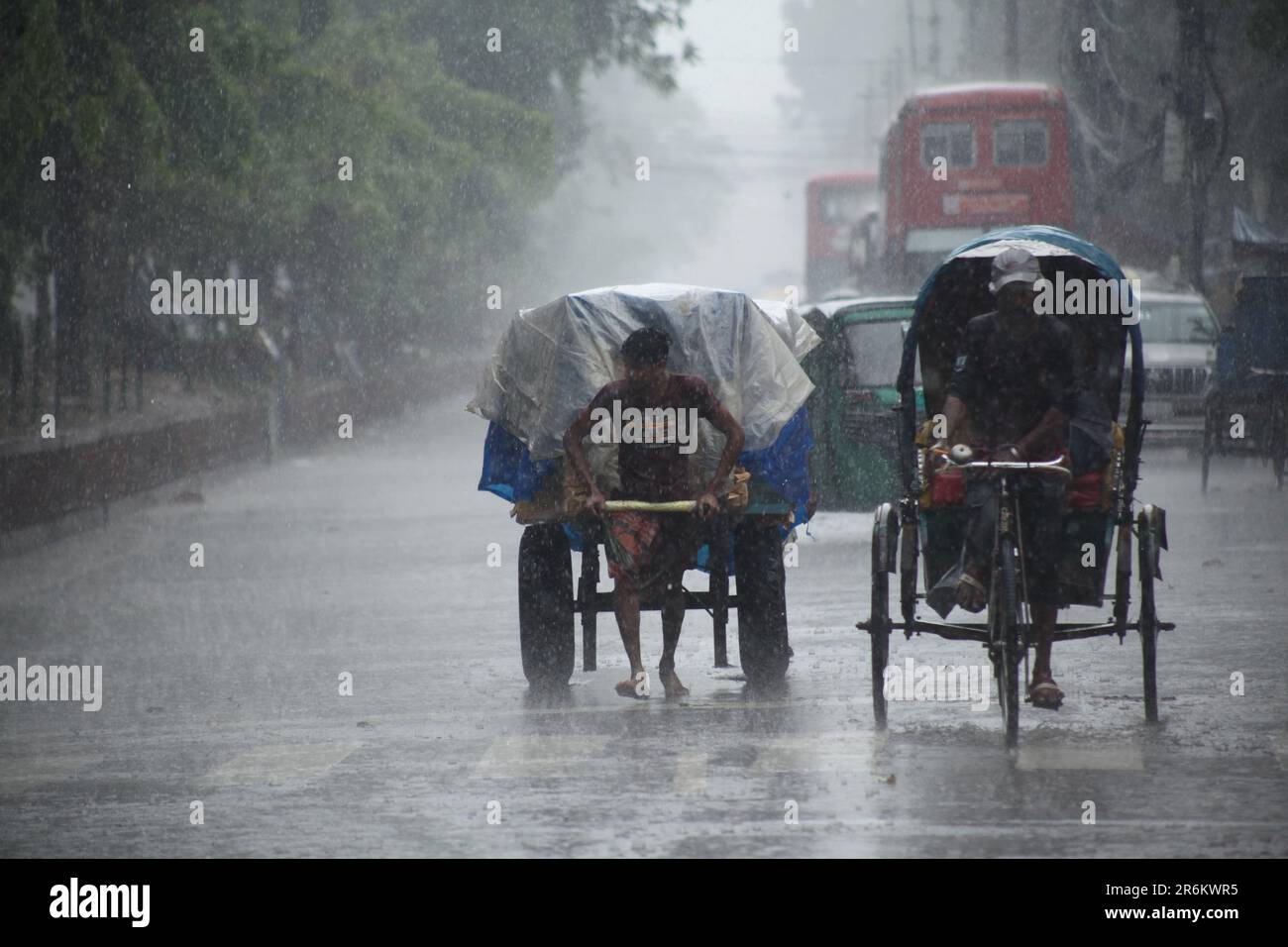 Estrattore di risciò che trasporta il passeggero quando la cameriera di pioggia pesante a dhaka, Bangladesh su 22march 2023.Nazmul islam/ alamy vivono Foto Stock